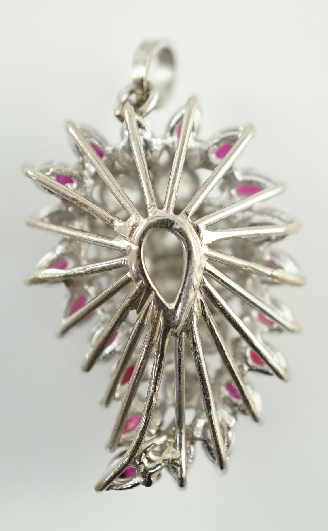 A modern white gold, ruby and diamond set pear shaped cluster pendant